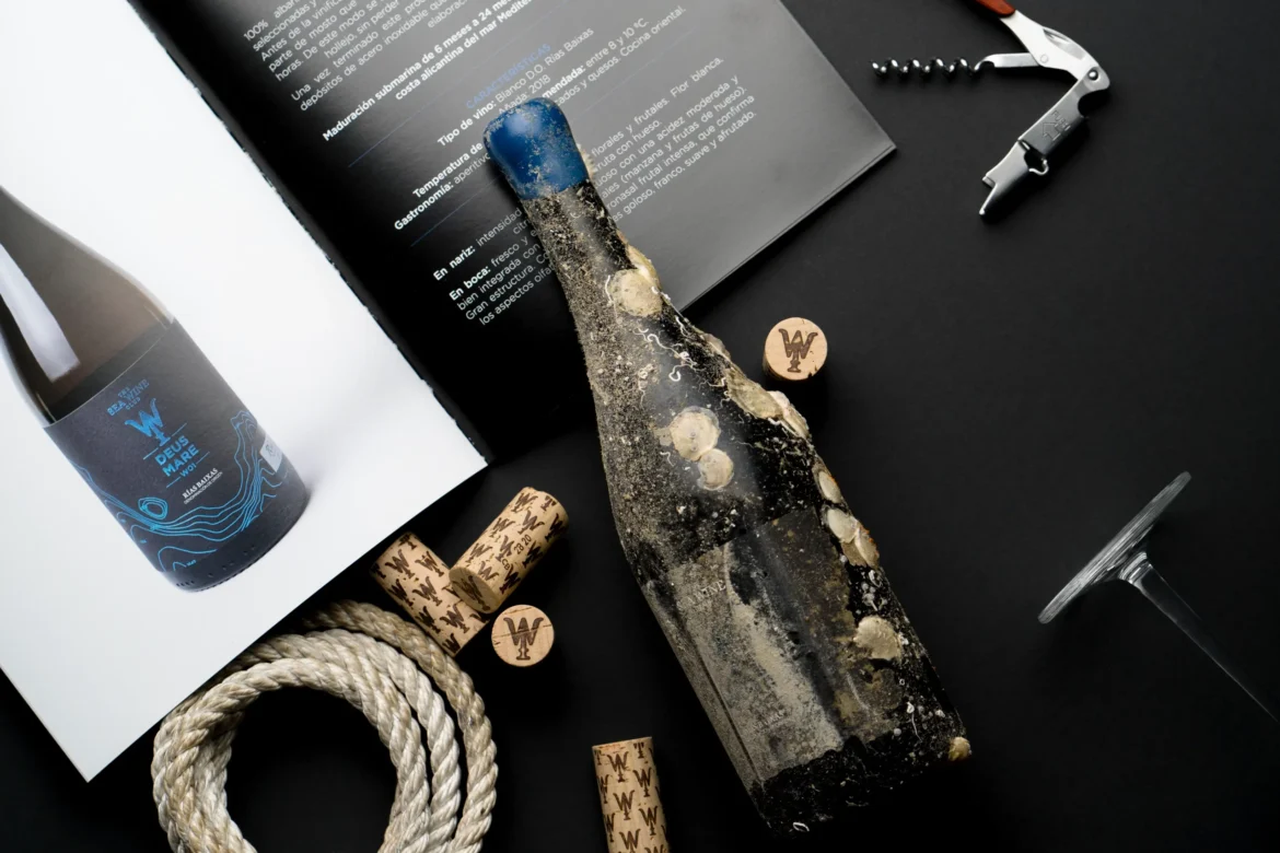 Botella de vino submarino cubierta de sedimentos junto a corchos y material de cata.